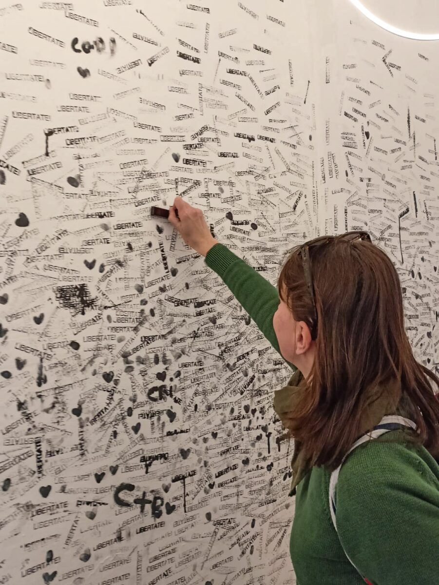 Il muro con i timbri della parola Libertate. che i visitatori sono invitati a lasciare a loro volta Il muro con i timbri della parola Libertate. che i visitatori sono invitati a lasciare a loro volta